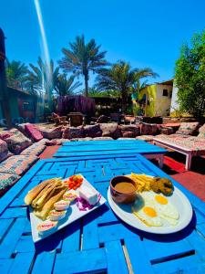 a table with breakfast foods on top of a blue table at Bishbishi Camp Dahab in Dahab