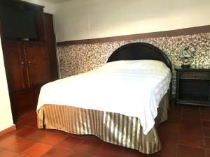 um quarto com uma cama e uma televisão na parede em La Casa de Taty em Valledupar