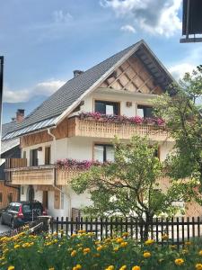 una casa con flores delante en LAKE HOUSE BOHINJ, en Bohinj