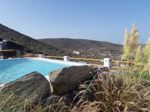 een zwembad met rotsen naast een berg bij 3 Paros *All Season* Villas in Parikia