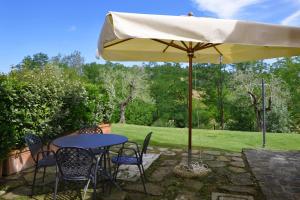 een tafel en stoelen onder een gele paraplu bij Francigena Apartments Castelfiorentino - Happy Rentals in Castelfiorentino