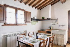 a kitchen with a table and chairs in a room at Cottage Assolata overlooking the Orcia valley in Tuscany in Radicofani