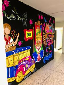 un mur avec une fresque d'un bus scolaire dans l'établissement La Quinta Bacana La Campiña, à Barranquilla