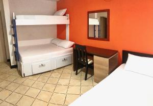 a bedroom with a bunk bed and a desk and a bunk bed at La Quinta Bacana La Campiña in Barranquilla