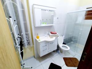 uma casa de banho com um WC, um lavatório e um chuveiro em Casa Julieta em Resende
