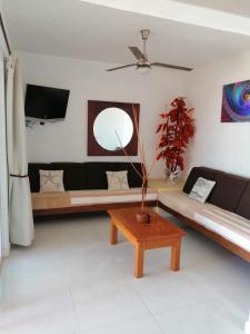 a living room with a couch and a table at Casa La Quinta Ola in Troncones