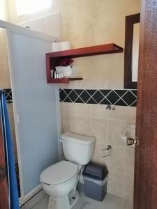 a bathroom with a toilet and a sink at Casa La Quinta Ola in Troncones +5 photos
