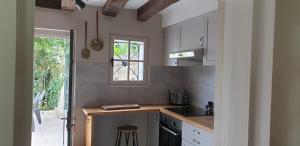 cocina con encimera, fregadero y ventana en La petite maison en Saint-Aignan