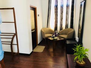 een hal met twee stoelen en een tafel en een spiegel bij St CLAIRE'S GREEN Negombo Hotel & Hostels in Negombo