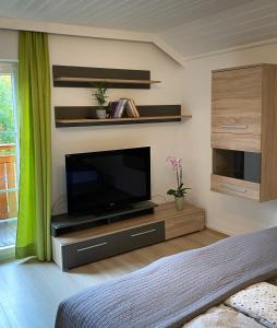 uma sala de estar com uma televisão de ecrã plano num centro de entretenimento em Apartment Bergfeeling em Russbach am Pass Gschütt