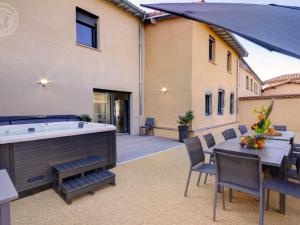 eine Terrasse mit einer Badewanne, einem Tisch und Stühlen in der Unterkunft Gîte Montchal, 6 pièces, 12 personnes - FR-1-496-234 in Montchal