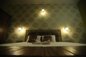 a bedroom with a bed with two lights on the wall at Karta-Purakh an Ayurvedic Stay in Amritsar