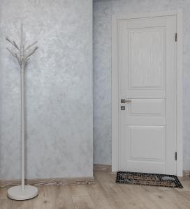 eine weiße Tür in einem Zimmer mit einer Vase in der Unterkunft Golden Violin ! Apartments Lviv in Lwiw