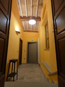 a hallway with a door and a stool and a ceiling at Bed and Breakfast Dal Tenente in SantʼAngelo in Vado