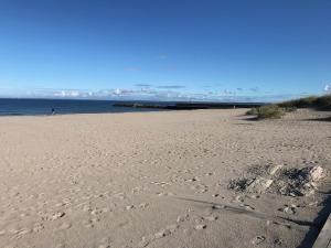plaża z odciskami stóp w piasku i oceanie w obiekcie Rivera Hill w mieście Båstad