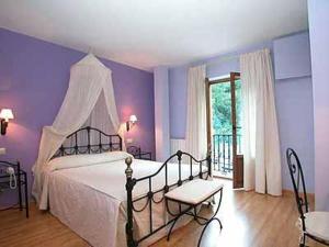 Hotel Cosgaya في كوسغايا: غرفة نوم بسرير ابيض وجدار ارجواني