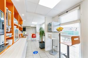 an office with a kitchen with a table and chairs at Kyriad Direct Annemasse - Genève in Gaillard