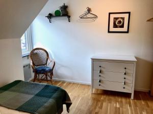 sypialnia z łóżkiem, komodą i krzesłem w obiekcie Rivera Hill w mieście Båstad
