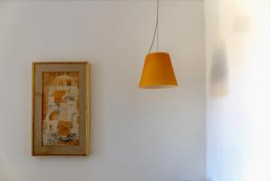 a light hanging on a white wall with a picture at Hotel Bellavista in Anacapri
