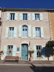 un edificio con una puerta azul y un banco en Alcôve Marine, en Gruissan