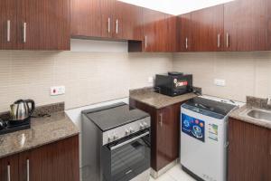 a small kitchen with a stove and a microwave at Mabaat - Al Waha 19 - 377 in King Abdullah Economic City