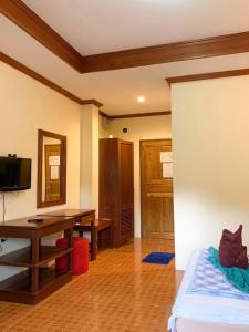 a room with a bed and a desk and a television at Koh Chang Hut Hotel in Ko Chang