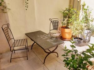 une table et deux chaises dans une pièce ornée de plantes dans l'établissement Alcôve Marine, à Gruissan
