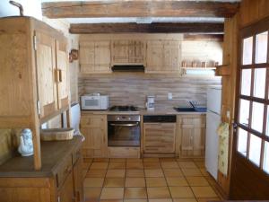 una piccola cucina con armadietti in legno ed elettrodomestici di Le Planay a Excoffonière