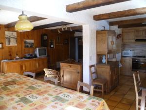 una cucina e una sala da pranzo con tavolo e sedie di Le Planay a Excoffonière