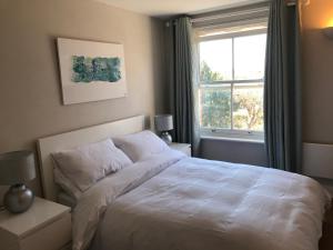 ein Schlafzimmer mit einem weißen Bett und einem Fenster in der Unterkunft Flagstaff Court in Kent