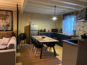 una cucina con tavolo, sedie e frigorifero di Le Maine N 5 - FLÉAC ANGOULEME - Suite Tilleul a Fléac