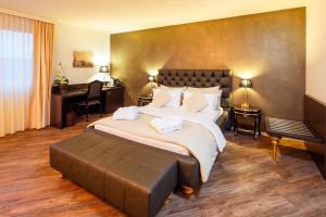 ein Hotelzimmer mit einem großen Bett und einem Schreibtisch in der Unterkunft Business Hotel First in Feusisberg