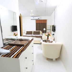 a bathroom with a tub and a bedroom with a bed at بيرحاء إبراء للسياحة in Ibrā