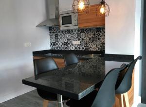 a dining room table with chairs and a microwave at Apartamentos Ciudad de Ronda in Ronda