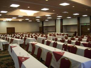 a banquet hall with white tables and red chairs at FairBridge Extended Stay, a Kitchenette Hotel in Idaho Falls