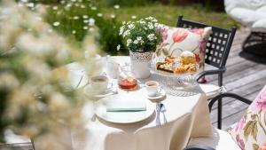 a table with a plate of food and cups of coffee at Natura Boutique Chalet Wellness SPA in Dobbiaco
