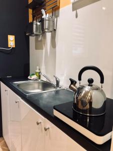 a tea kettle sitting on a counter next to a sink at Apartamenty Wojewódzka in Katowice
