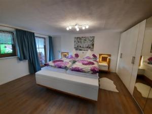 1 dormitorio con 1 cama grande con almohadas moradas en Ferienwohnung Kiliansblick in der Kilianmühle, en Berchtesgaden