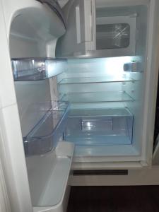 um frigorífico vazio com a sua porta aberta e prateleiras vazias em Luxuriöse Wohnung mit eigenem Garten em Augsburg