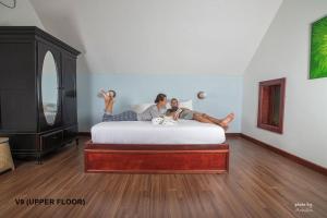 two people laying on a bed in a room at Tanjung Inn in Kuantan