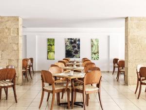 een eetkamer met tafels en stoelen en schilderijen aan de muren bij Esperia City Hotel in Rhodos-stad