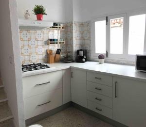 uma cozinha com armários brancos e um forno com placa de fogão em La Casa del Bienestar em Cabra