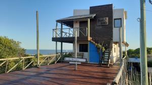 a building on a boardwalk with the ocean in the background at Cabañas Puerto Diablo in Punta Del Diablo