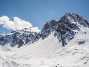 una montaña cubierta de nieve con un cielo azul en Magnifique Duplex Oneigedor Départ ski aux pieds et vue montagne en Tignes