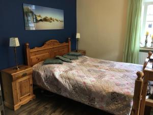 1 dormitorio con 1 cama con marco de madera en The Cozy Cottage, en Rieden
