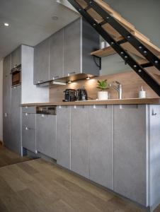 a kitchen with stainless steel appliances and wooden floors at Magnifique Duplex Oneigedor Départ ski aux pieds et vue montagne in Tignes