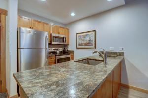 a kitchen with a stainless steel refrigerator and a sink at Co204 Copper One Lodge Condo in Copper Mountain