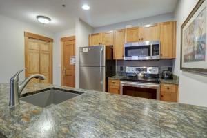 a kitchen with a stainless steel refrigerator and microwave at Co204 Copper One Lodge Condo in Copper Mountain