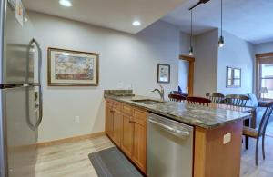 a kitchen with a sink and a refrigerator at Co204 Copper One Lodge Condo in Copper Mountain
