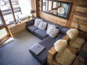 a living room with a blue couch and a window at Magnifique Duplex Oneigedor Départ ski aux pieds et vue montagne in Tignes